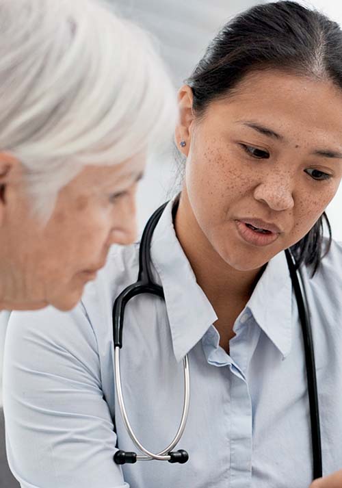 a female doctor talking to an older woman
